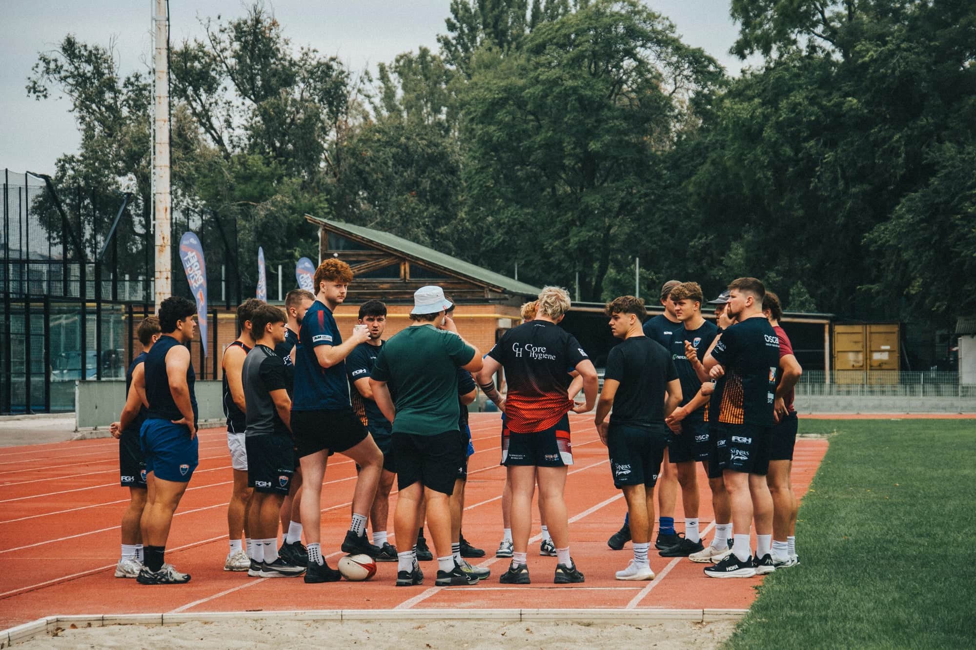 Atleten in een teamoverleg op de atletiekbaan