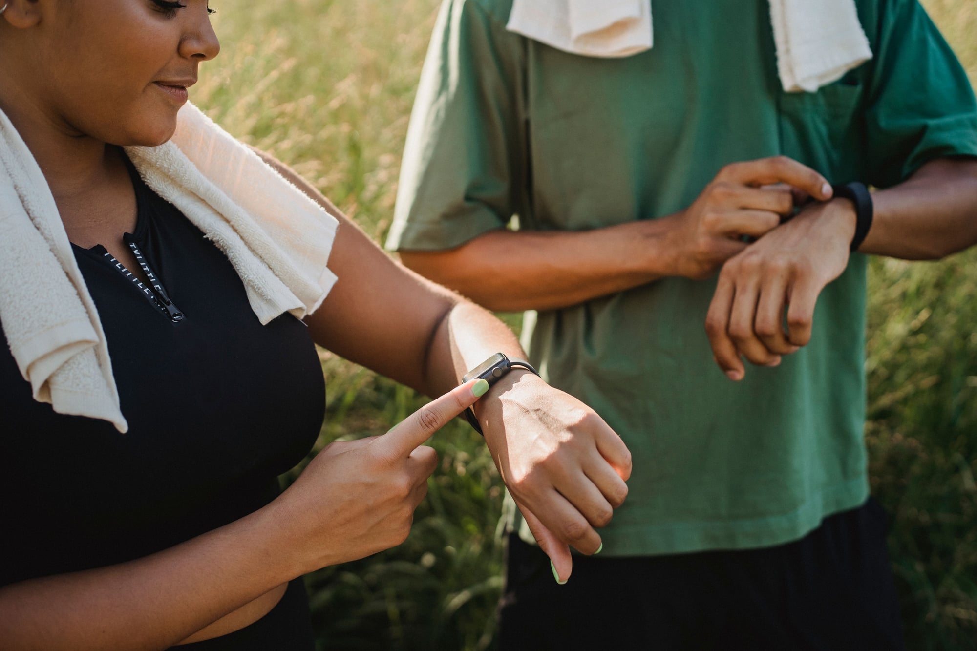 Twee sporters kijken op hun horloge