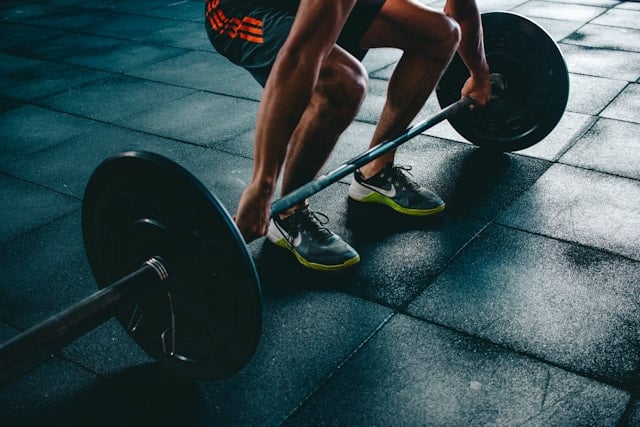 Hardloper en sporter die lunges doen in een sportschool