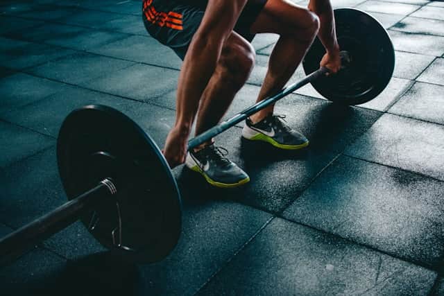 Runner and athlete doing lunges in a gym